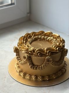 a golden cake sitting on top of a white counter next to a window sill