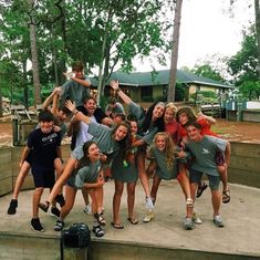 a group of young people standing on top of a cement step in front of trees