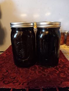 two mason jars sitting on top of a red doily