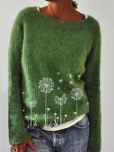 a woman wearing a green sweater with dandelions on it