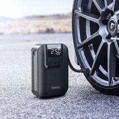 an electronic clock is plugged into the tire of a car, next to it's charging charger