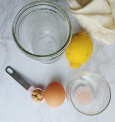 ingredients to make lemonade sitting on a counter next to a glass bowl and knife