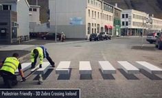 two men in yellow vests working on a crosswalk