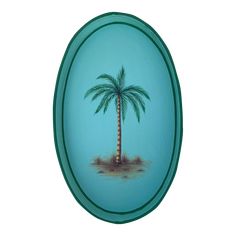 a palm tree painted on the side of a blue glass wall hanging ornament