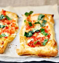 two slices of pizza sitting on top of a piece of parchment paper