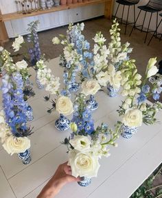 a table topped with blue and white vases filled with flowers