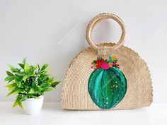 I love Mexico celebrates the native crafts of Mexico and the artists that produce them, enabling them and their communities to get recognized for their talented work and achieve economic stability for their families. This listing is for this bag shown on the picture, made of palm leaves and 100% natural materials. The tassels or other accessories on the picture are not included. The cactus paint is 100% made by hand. Measurements : please see pictures for exact size. All size units are in inches Artisan Bag For Summer Gift, Bohemian Straw Tote Beach Bag, Bohemian Beach Bags For Gifts, Bohemian Basket Beach Bag, Summer Bucket Straw Bag As Gift, Artisan Summer Bucket Bag, Summer Bucket Straw Bag For Gifts, Bohemian Straw Beach Bag, Green Bohemian Straw Tote Bag