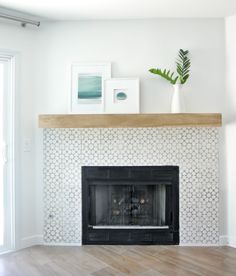 a living room with a fireplace and pictures on the mantle