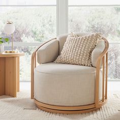 a chair with a pillow on it next to a table and window in the background