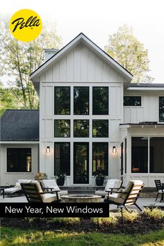 a large white house with lots of windows and furniture in front of the patio area