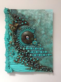 a piece of art that looks like it is made out of turquoise and gold beads