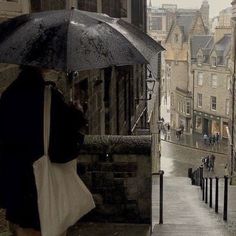 a woman with an umbrella is walking down the street