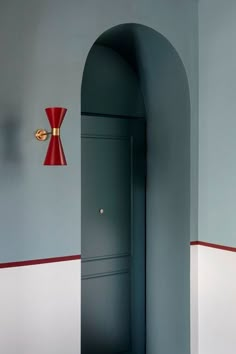 an open door in a gray room with red accents