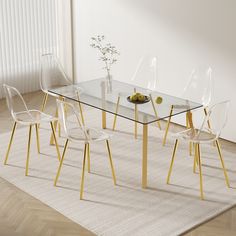 a glass dining table with gold legs and clear chairs in front of a white wall