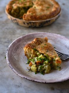 a piece of quiche on a plate with a fork in front of the pie