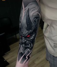 a man's arm with an evil demon tattoo on it