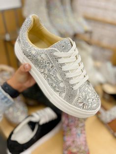 Put a little sparkle in your step with the REILY rhinestone sneakers. This sneaker can be paired with your best dress or favorite jean! Its intricate pattern is an eye-catching way to make a statement, no matter where you're wearing it. Manmade rhinestone platform sneakers Lace up closure Textile lining Rubber sole 1.5 inch platform Imported Luxury Party Sneakers With Glitter Accents, Trendy Embellished Sneakers For Streetwear, Embellished Lace-up Sneakers For Streetwear, Crystal Embellished Lace-up Sneakers For Streetwear, Embellished Low-top Sneakers For Spring, Casual Bedazzled Sneakers, Silver Embellished Low-top Sneakers, Casual Embellished Sneakers For Spring, Embellished Lace-up Sneakers For Spring