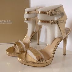 Brand: Michael Michael Kors Style: Ashby Sandal Material: Metallic Leather Color: Gold Size 7.5 / 38 Heels: ~ 4.25” Brand New In Box! Michael Kors Evening Sandals With Heel Strap, Michael Kors Synthetic Sandals For Evening, Michael Kors Ankle Strap Sandals, Michael Kors Synthetic Evening Sandals, Michael Kors Luxury High Heel Sandals, Luxury Michael Kors High Heel Sandals, Michael Kors Formal Sandals With Heel Strap, Luxury Michael Kors Sandals For Spring, Luxury Gold Synthetic Heels