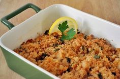 a casserole dish filled with meat and garnished with a lemon wedge