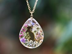 This pendant necklace showcases a sweet kitty amidst real pressed flowers, delicately encased in resin. Steps to Order: ( With Cat Fur)  1) Choose your necklace and place an order. 2) You will receive a message from me, including the address where you need to send the hair (please mark your Etsy account name if the shipping address name is different). 3) Once I receive your pet hair,I will need 2-3 days to craft the unique piece and ship it back to you. Material: 14k gold filled chain and components or Silver Pressed Flowers Chain Length: 18" (45cm) Pendant Size: 2.5 cm x 3cm ( 0.98" x 1.18" ) Every pieces is made by hand and unique, therefore each piece might be slightly different. Comes packed with a gift box. This is a handmade product, there is a tiny possibility of imperfections and m Pet Hair Resin, Resin Cat Tag, Real Flower Necklace, Lover Necklace, Necklace Cat, Sweet Kitty, Cat Pendant, Cat Tags, Cat Pendants