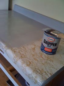 a can of paint sitting on top of a table next to a white refrigerator freezer