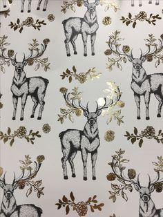 a white and gold deer wallpaper with pine cones on it's antlers