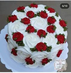 a cake with white and red roses on it is sitting on a platter, ready to be eaten