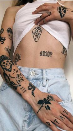 a woman with many tattoos on her arms and chest is holding onto the side of her stomach