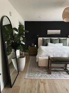 a bedroom with black walls, white bedding and wooden floors is pictured in this image