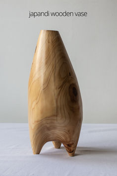 a wooden vase sitting on top of a white table