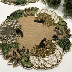 two placemats that have been decorated with green leaves and pumpkins on them