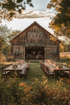 an outdoor wedding venue with tables and chairs set up in front of a rustic barn