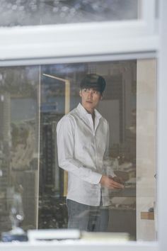 a young man standing in front of a window