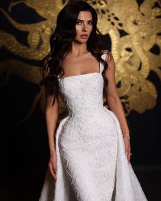 a woman in a white dress posing for the camera