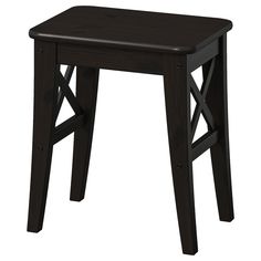 a small wooden stool with cross legs on an isolated white background for use as a side table