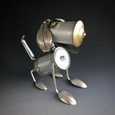 a metal figurine with spoons and a light bulb on it's head