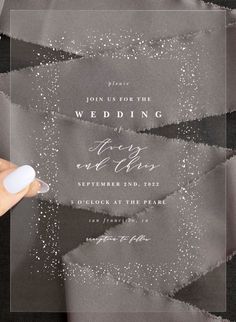 a person holding a pen in front of a wedding card