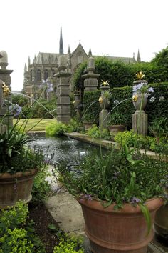 the garden is full of beautiful flowers and greenery, along with an old castle like building in the background