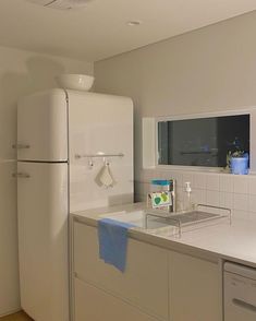 a white refrigerator freezer sitting inside of a kitchen next to a sink and counter