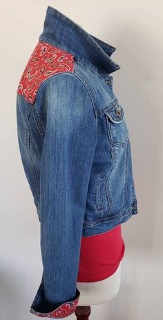 Get your red boots on and hit the dance floor in this bandana trimmed denim jacket! This distressed ChiOle size M denim jacket is the perfect choice for the red bandana print on its traditional western back yolk!  I added just a bit more inside the cuffs for fun accents when you roll up those sleeves! When you purchase a jacket from me, you can be assured that you are purchasing a one of a kind item. I make only one of each jacket.  I will ship this beautiful jacket to you for free! Please measure carefully to ensure a good fit. Please note that fabricator sizes run differently. I strongly urge you to check your measurements to get the fit that you want. If you don't have a seamstress tape (a fabric one), use a string around yourself, then measure this with a tape measure or ruler. My meas Casual Denim Jacket For Winter Festival, Casual Winter Festival Denim Jacket, Fitted Denim Jacket For Rodeo, Casual Medium Wash Denim Jacket For Festivals, Fitted Western Denim Jacket For Rodeo, Fitted Medium Wash Denim Jacket For Festival, Trendy Fitted Denim Jacket For Festivals, Western Style Fitted Dark Wash Denim Jacket, Fitted Western Dark Wash Denim Jacket