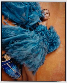 a woman laying on the ground in a blue dress