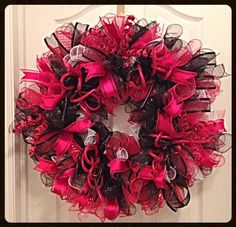 a red and black wreath hanging on the front door