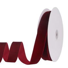 a roll of red satin ribbon on a white background