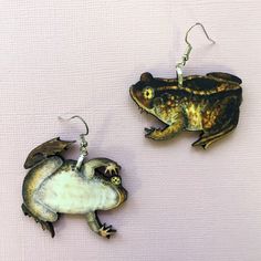 "These spadefoot toad earrings are made out of laser cut wood and have stainless steel hooks. These earrings are super light to wear. The large set are about 1.8\"x1.5,\" and the smallest are about 7/8\"x3/4.\" They can be a part of your witchy or Halloween outfit, or just for frog and toad lovers! Due to the handmade nature of this product, there may be slight variations in appearance and color. However, it will still be beautiful! Find us on instagram and facebook for new products, discounts, Random Earrings, Spadefoot Toad, Toad Frog, Weird Earrings, Frog Earrings, Earring Inspo, Perfume Jewelry, Witch Earrings, Tough As Nails