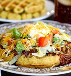 a plate with waffles topped with chili cheese and lettuce