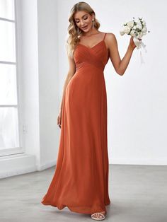 a woman in an orange bridesmaid dress holding flowers