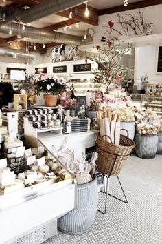 the inside of a store with baskets and flowers