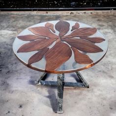 a glass and wood table sitting on top of cement