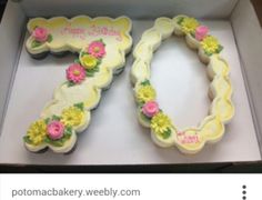 two decorated cookies in a box with happy birthday written on the top and flowers on the bottom