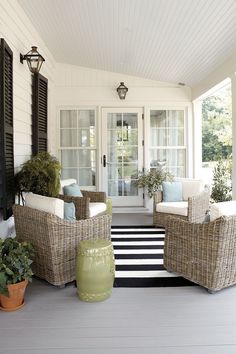 the front porch is decorated with wicker furniture